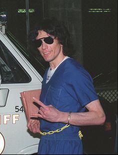 a man in blue shirt and sunglasses holding a book