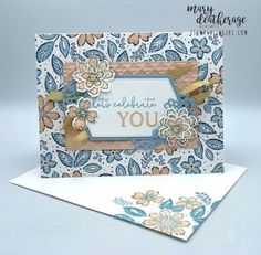 a card with flowers on it and the words thank you written in gold, blue and white