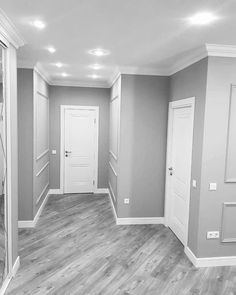 an empty room with white doors and gray walls