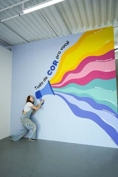 a woman is painting a wall with colorful colors