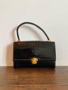 This vintage retro handbag in black leather is from 1950s.  It is has an envelope purse-bag design: shaped like a letter envelope with a front flap and turn-lock closure system with a top leather handle, made of black genuine leather with gold and silver toned hardware, lined with smooth and soft black leather. The  interior has 2 open pockets and a third on with a leather top. Such an Elegant french leather purse! Condition: The purse is in good used vintage condition and shows signs of normal Vintage Luxury Bags With Cc Turnlock Closure, Luxury Women's Bags For Vintage Events, Luxury Vintage Bags With Gunmetal Hardware, Luxury Vintage Flap Bag For Business, Luxury Vintage Bags With Leather Lining, Luxury Elegant Bags For Vintage Fashion, Luxury Retro Satchel For Formal Occasions, Affordable Vintage Formal Bags, Luxury Vintage Flap Bag