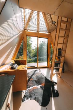 a living room filled with furniture next to a window and a staircase leading up to the second floor