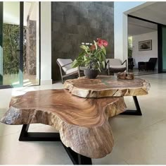 a wooden table sitting in the middle of a living room next to a planter