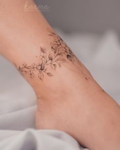 a woman's foot with a flower tattoo on her left side and the bottom part of her leg