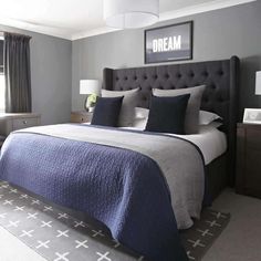 a bedroom with gray walls and blue bedding