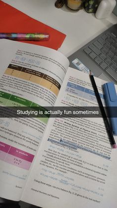 an open book sitting on top of a desk next to a keyboard