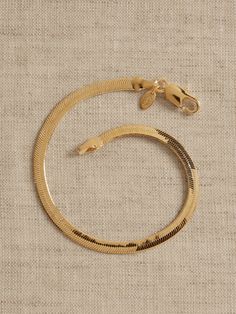 a gold bracelet on a beige background