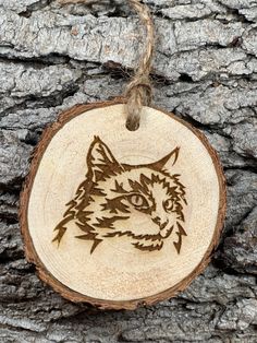 a wood burned ornament with an image of a cat's head on it