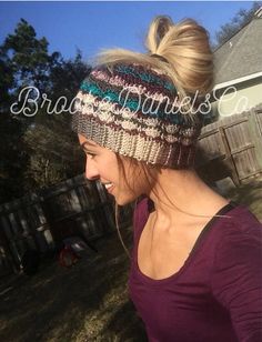 a woman wearing a multicolored knitted beanie with ponytail in the back