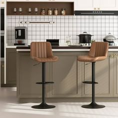 two stools in the middle of a kitchen with white tile on the walls and floor