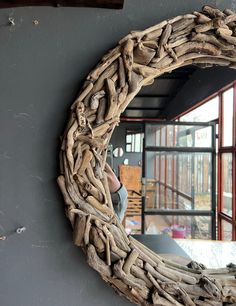 a mirror made out of driftwood is hanging on the wall