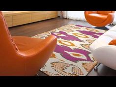 an orange and white chair sitting on top of a wooden floor next to a rug