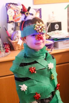 a young boy dressed up as a christmas tree