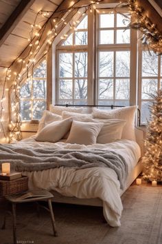 an attic bedroom decorated for christmas with lights on the windows and a bed covered in blankets