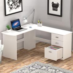 a white desk with drawers and a laptop on it in front of a wall mounted painting