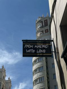 a sign hanging from the side of a building that says from madrid with love on it