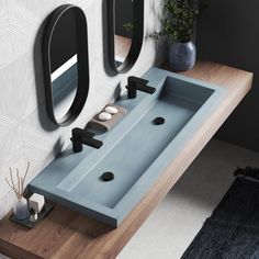 a bathroom sink sitting under two mirrors on top of a wooden counter next to a mirror