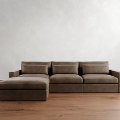 a couch sitting on top of a hard wood floor next to a white wall in an empty room