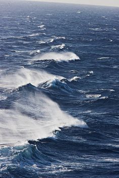 several large waves in the ocean on a sunny day