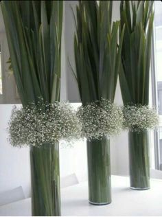 three tall vases with baby's breath flowers in them