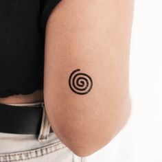 a woman's arm with a tattoo that has a spiral design on the side