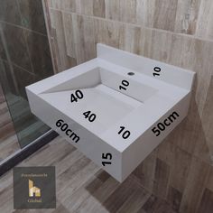 a white sink sitting in the middle of a bathroom next to a shower stall with numbers on it