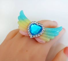 Resin Glitter Ring - Glitter Wings Jewelry - Glitter wings ring - Heart Ring - Kawaii Ring - Valentine Gift - Heart Wing Jewelry-Kawaii Ring - Harajuku Fashion - fairy Tale Jewelry this listing is for a lovely angel wings ring with a beautiful heart in the middle. The ring is handmade out of resin. You will get exactly the same as shown on the picture. The pink filigree ring is adjustable. The wings are 7 cm large (2.5 inch) some parts are not compatible with water and shouldn't be submerged. ju Cute Glitter Jewelry Gift, Cute Adjustable Party Rings, Adjustable Cute Party Rings, Cute Adjustable Rings For Parties, Cute Party Ring Jewelry, Kawaii Ring, Angel Wings Ring, Mode Harajuku, Wings Jewelry