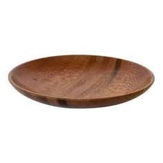 a wooden bowl sitting on top of a white surface with a brown stripe pattern in the center