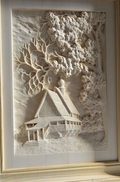 an intricately carved paper art depicting a house in the woods