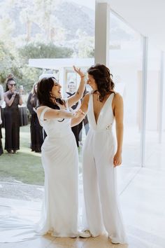 two women standing next to each other in front of a crowd