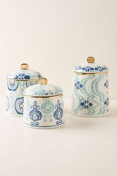 two blue and white canisters sitting on top of a table