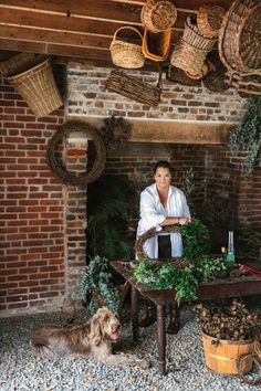 a woman standing in front of a table surrounded by plants