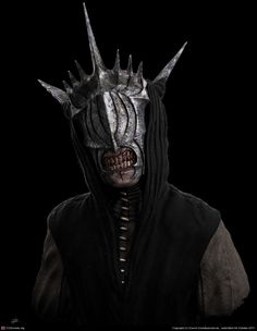 a man in a black outfit with horns and fangs on his face, wearing a mask