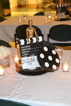 a table topped with a cake covered in polka dots and a movie clapper on top of it