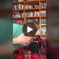 a woman is bending over to touch a child's head in front of a bookshelf