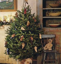 a teddy bear sitting in a chair next to a christmas tree