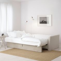 a large white couch sitting in a living room next to a table with two stools