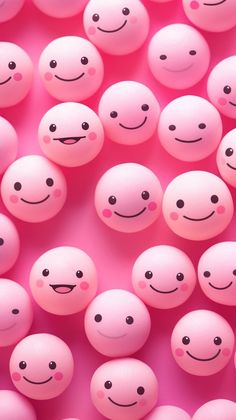 many pink balls with black eyes and smiling faces are arranged in the shape of smiley faces