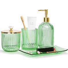 green glass bathroom accessories with gold accents