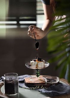 a woman is serving desserts on a plate with a spoon and fork to it