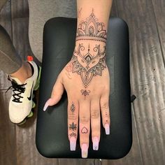 a woman's hand with tattoos on it sitting on top of a black chair