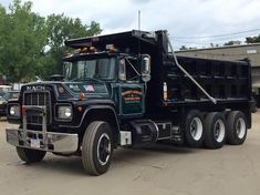 a black dump truck parked in a parking lot