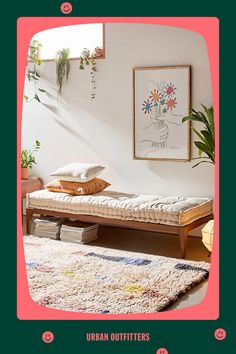 a room with a bed, rug and plant on the wall above it that says urban outfitters