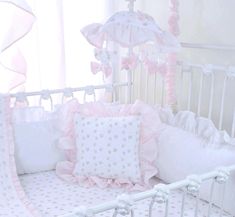 a white crib with pink and white bedding