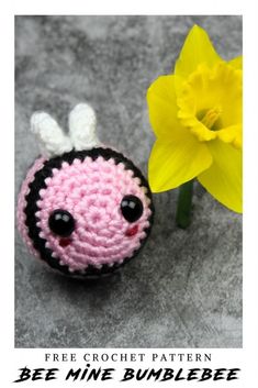 a crocheted bee is next to a yellow flower