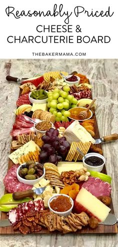 an image of a cheese and charcute board with grapes, olives, crackers