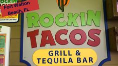 the sign for rockin'tacos and tequila bar in front of other signs