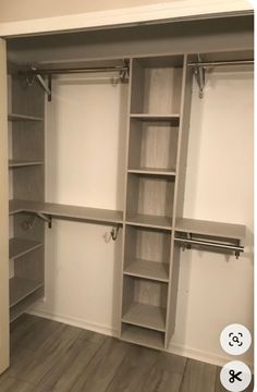 an empty walk in closet with white walls and open shelves on the wall, along with wooden flooring