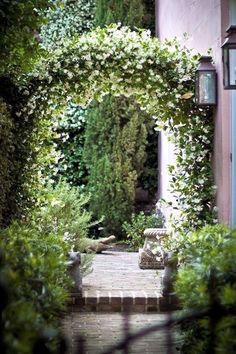 an archway is surrounded by greenery and stone steps