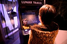 a person standing in front of a machine with a screen on it's side